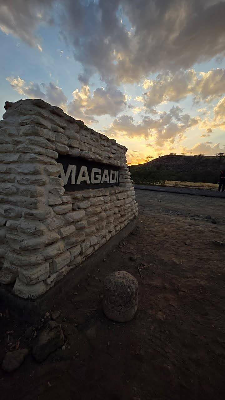 Stone signage for Lake Magadi at sunset with clouds overhead